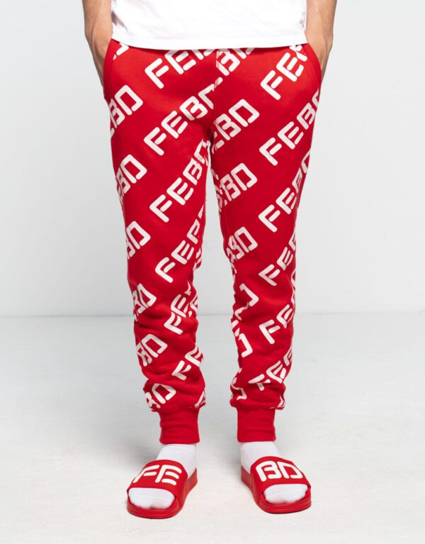 Mannelijk model draagt een rode FEBO Super Goeie Joggingbroek